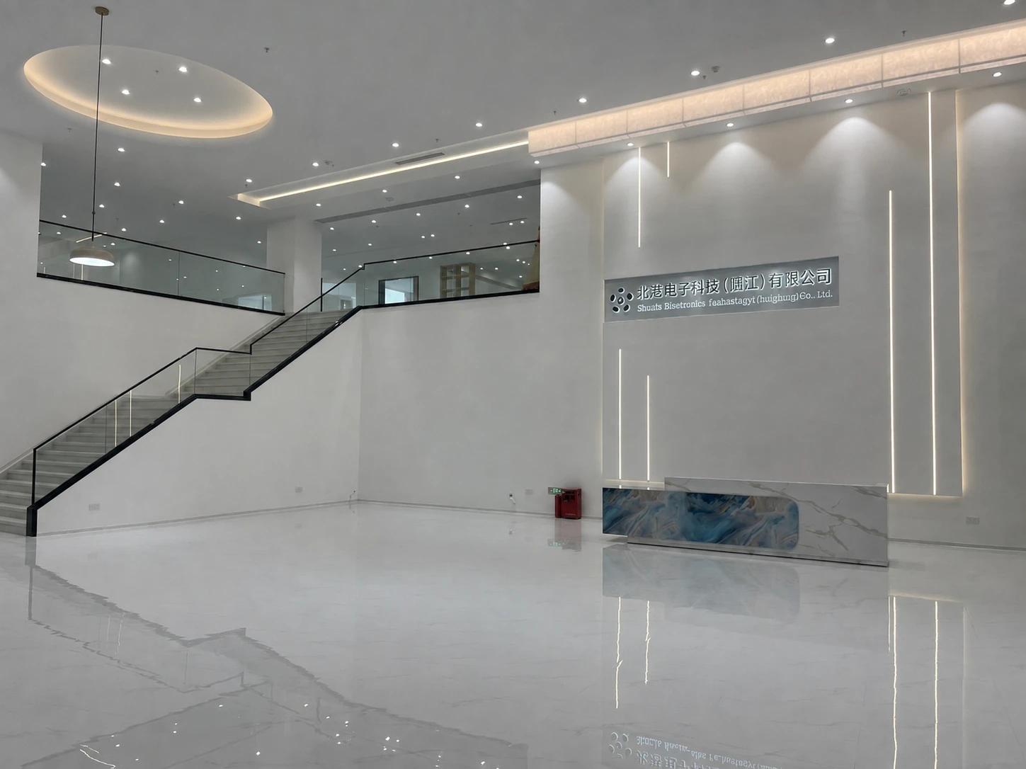 Spacious factory reception with marble floor, staircase and company signage